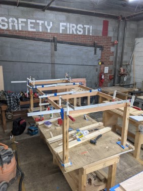 table frame being clamped and glued in workshop